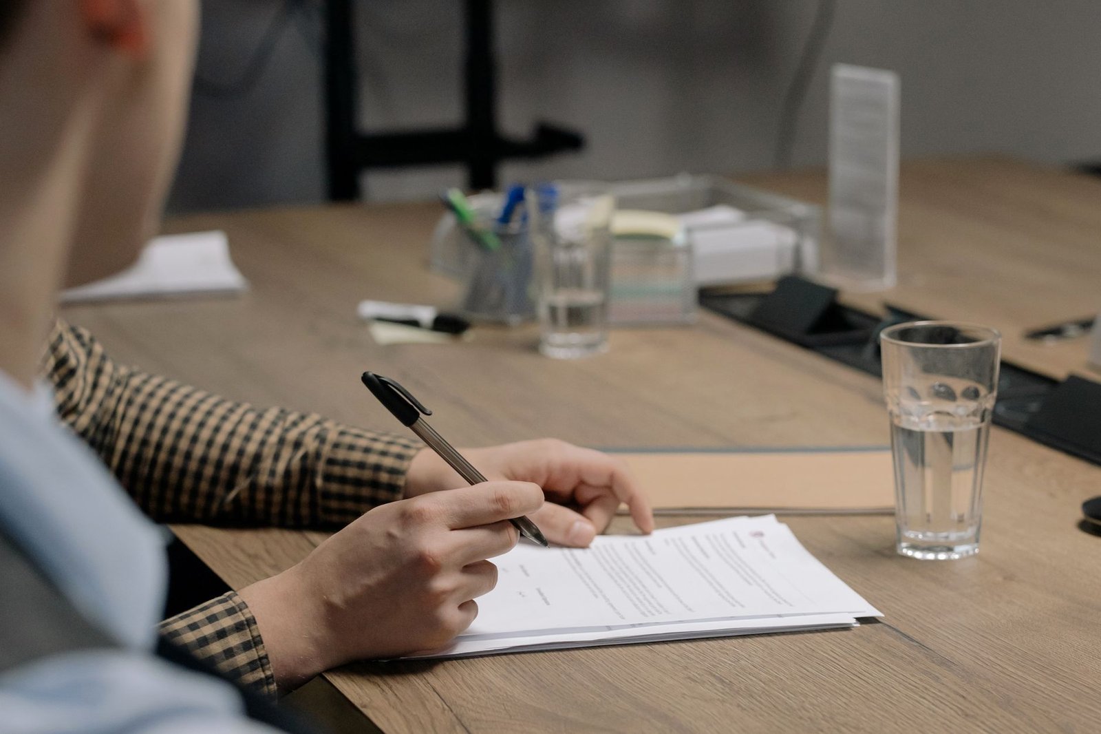 Persona firmando un documento de reclamación en un escritorio